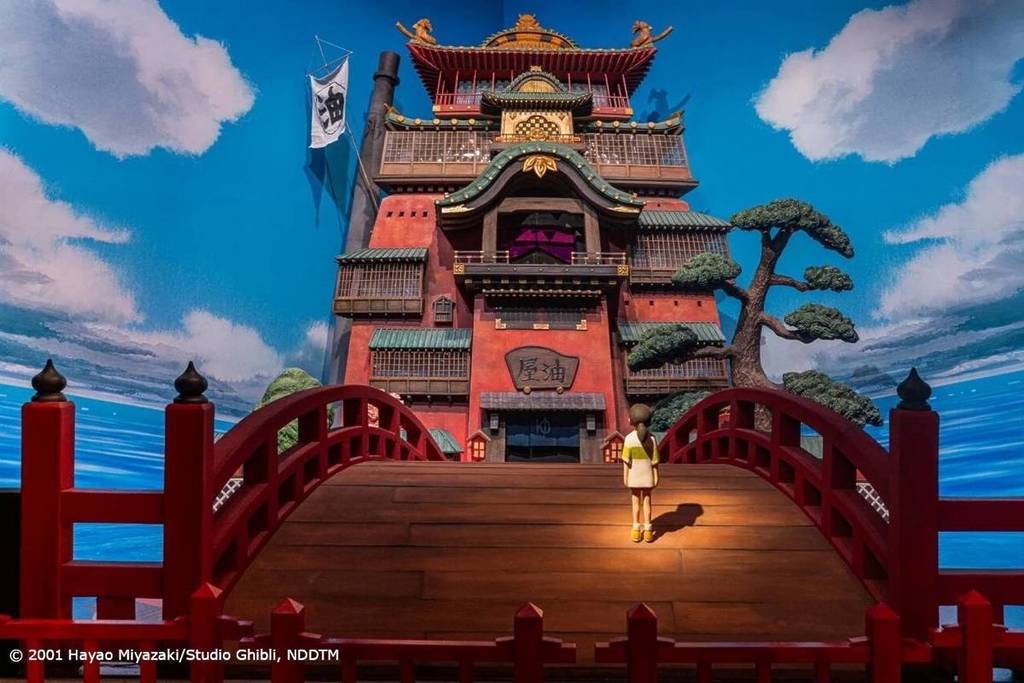Spirited Away's Chihiro crossing the red bridge towards Yubaba's spirit bathhouse