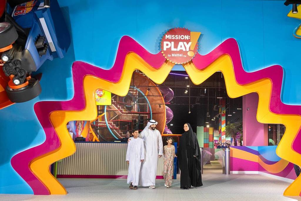 A family leaving Mission: Play! by Mattel with happy faces and memories from a fun school holiday