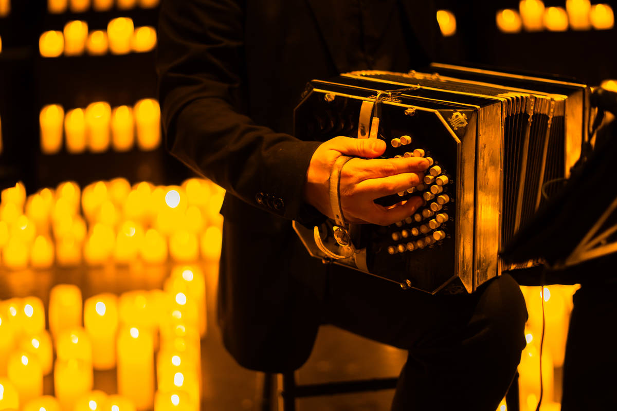 Primer plano de las manos de un músico tocando el acordeón durante un concierto Candlelight.