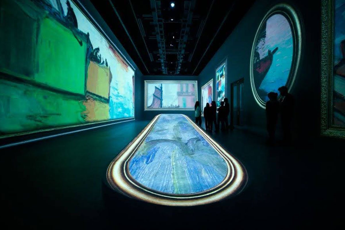 Sala de arte con proyecciones envolventes inspiradas en las obras de Quinquela Martín, una de las experiencias inmersivas Buenos Aires