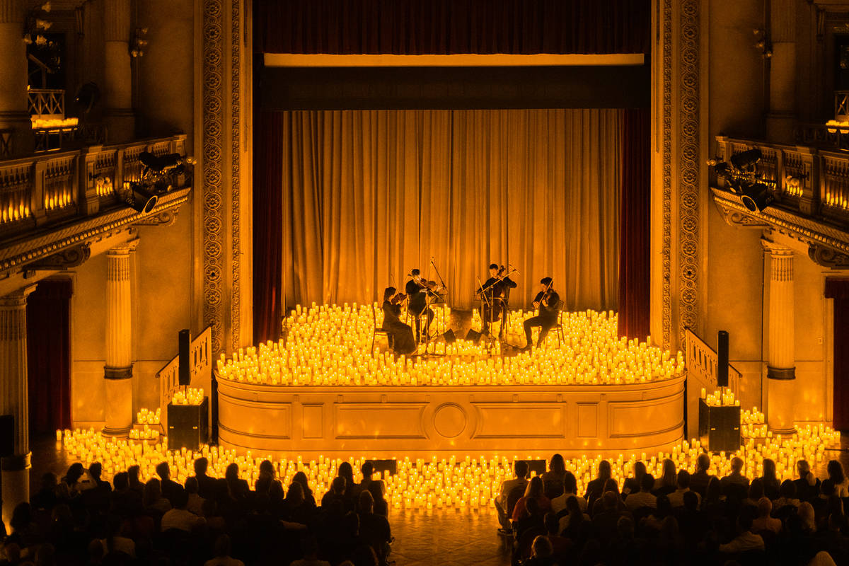 Cuarteto de cuerda tocando rodeado de cientos de velas en el escenario del Auditorio San José, dentro de los conciertos Candlelight en Buenos Aires