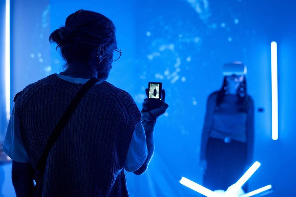 Hombre tomando una foto a una persona usando gafas de realidad virtual en las experiencias inmersivas en Buenos Aires
