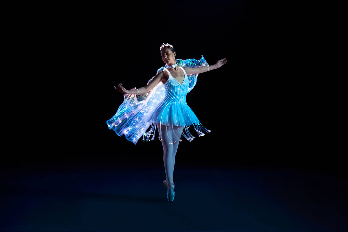 Bailarina de Ballet of Lights Buens Aires en un escenario oscuro vestida con un traje luminoso azul