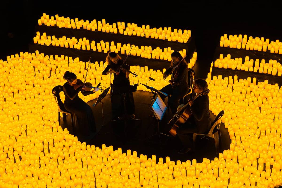 Cuarteto de cuerda tocando en vivo rodeado de miles de velas durante un concierto Candlelight.