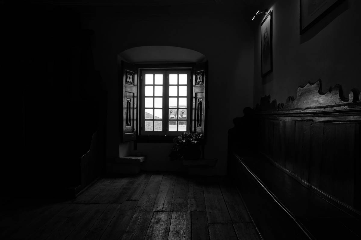Estancia a oscuras donde entra la luz por un ventanal