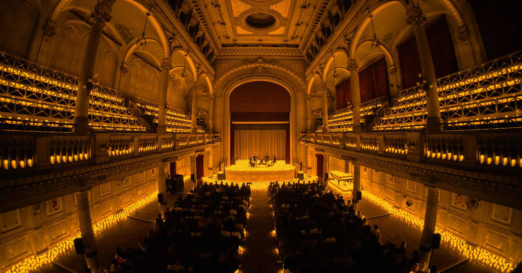 Plano general del interior del Auditorio San José de Buenos Aires cubierto por miles de velas durante un concierto Candlelight.