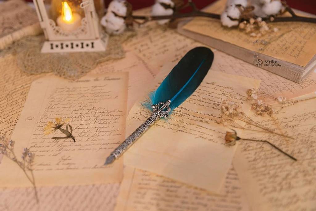 Letters written in pen on a table by candlelight
