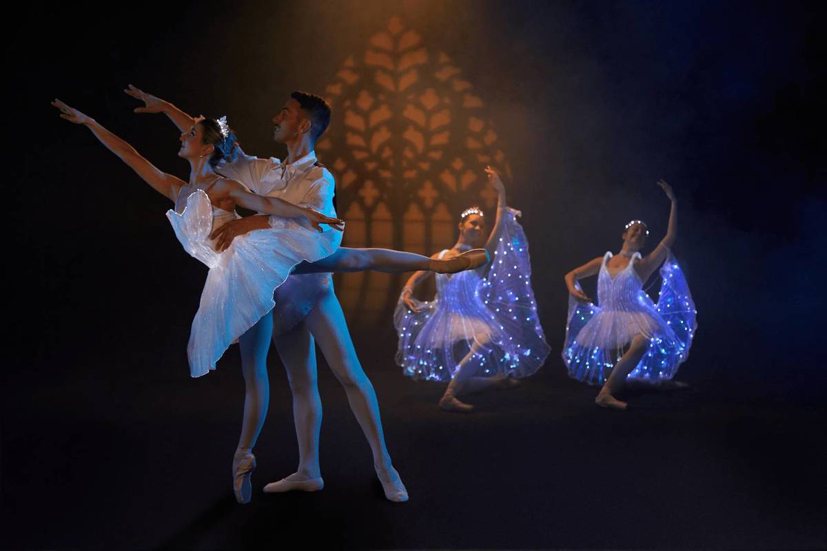 Cuatro bailarines con trajes cubiertos de luces bailan sobre un escenario en Ballet of Lights.