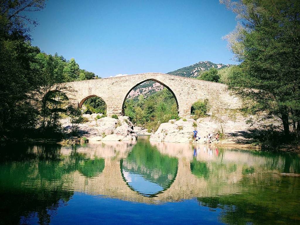 Gli specchi d’acqua turchese sotto un ponte medievale a un’ora da Barcellona per fare il bagno quest’estate