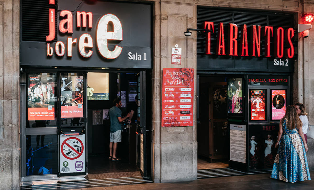 Entrada del Jamboree y Tarantos en la Plaza Real de Barcelona, con carteles de conciertos y personas en la taquilla.