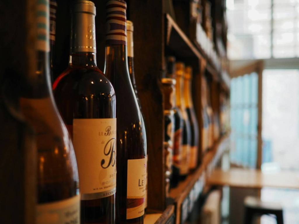 Primer plano de muchas botellas de vino sobre una estantería.
