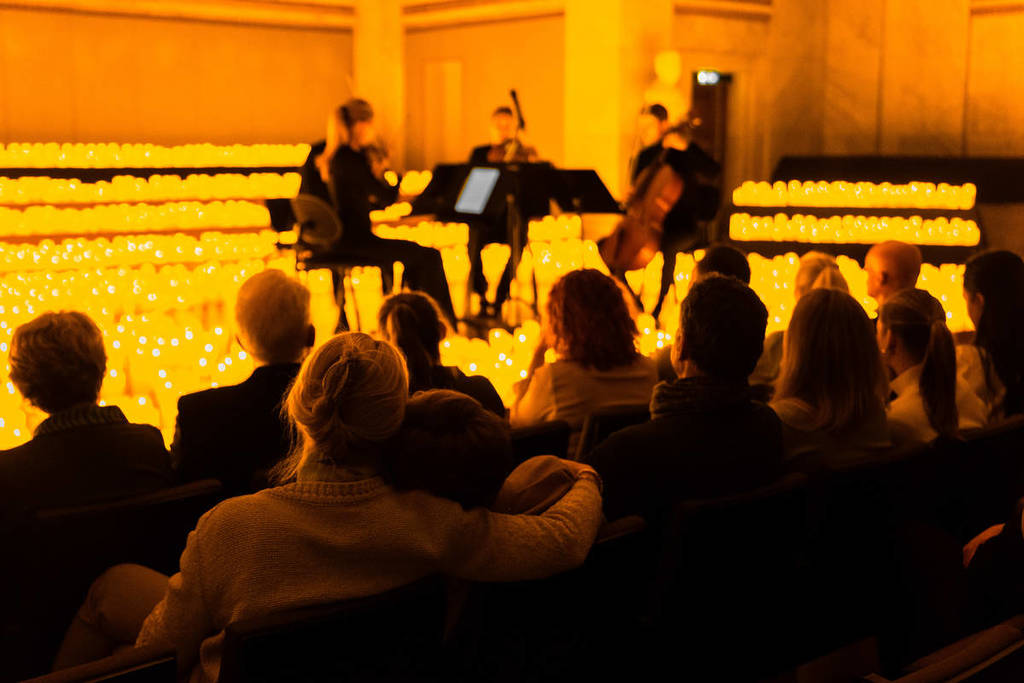 quarteto de cordas em um palco repleto de velas de LED em um concerto Candlelight
