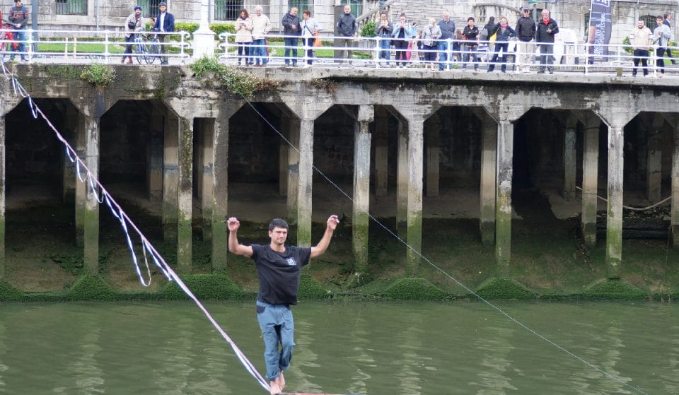 Un funambulista cruza la ría de Bilbao sobre una cuerda elástica