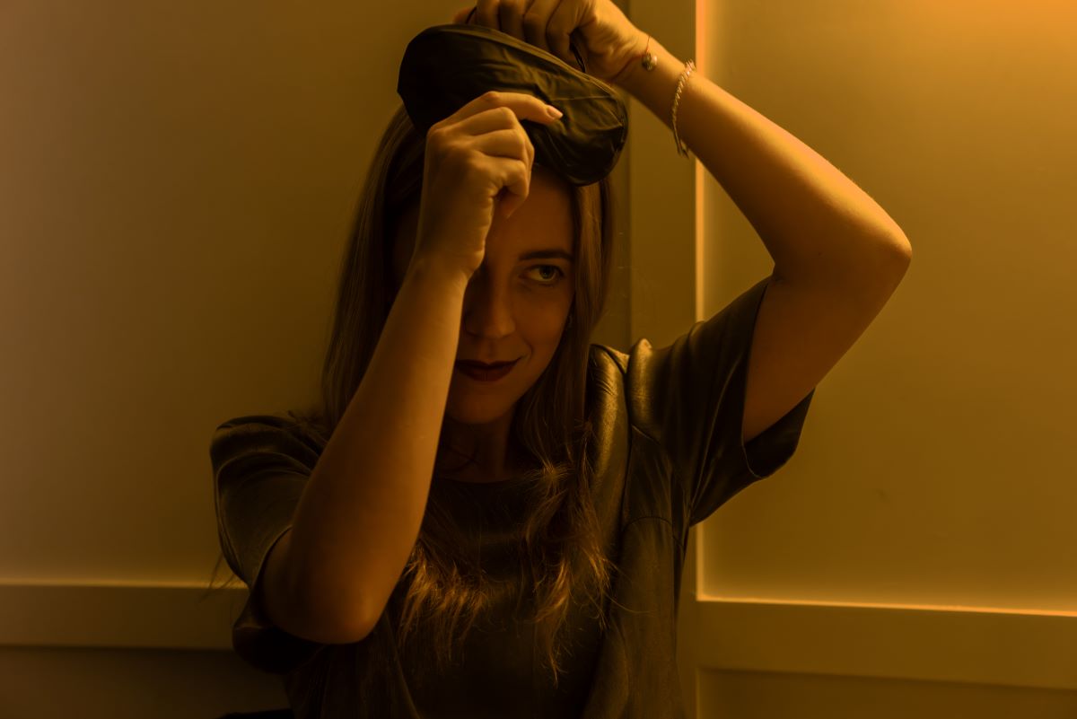 A woman putting on a blindfold