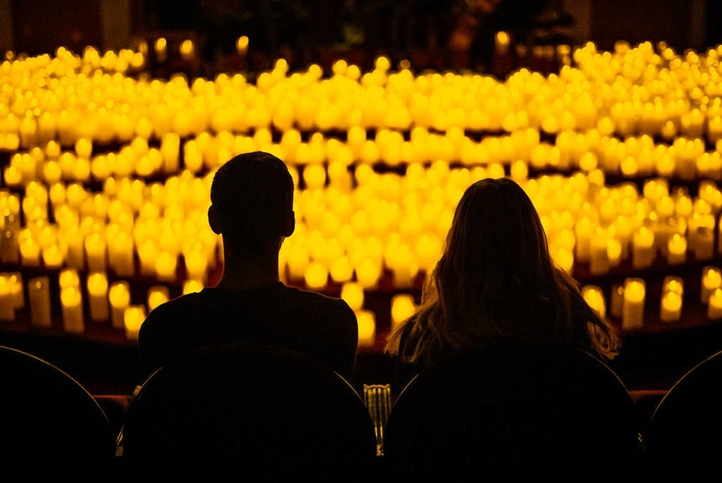 A silhouette of a couple enjoying a Candlelight concert.