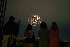 A crowd watches drones fly over a string quartet