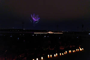 A crowd watches drones fly over a string quartet