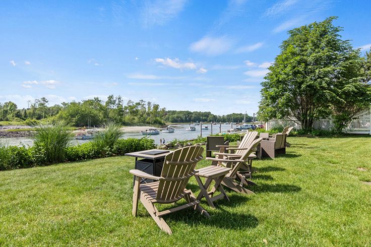 adirondack chairs overlooking river and lobster boats on clear day