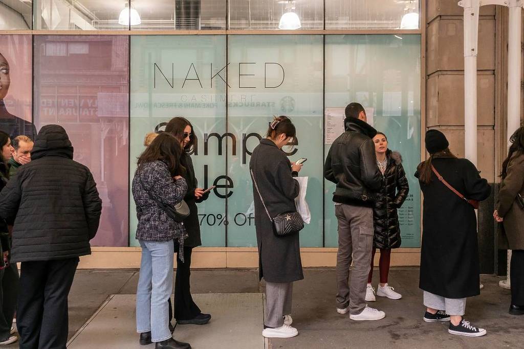 people waiting in line outside of a sample sale