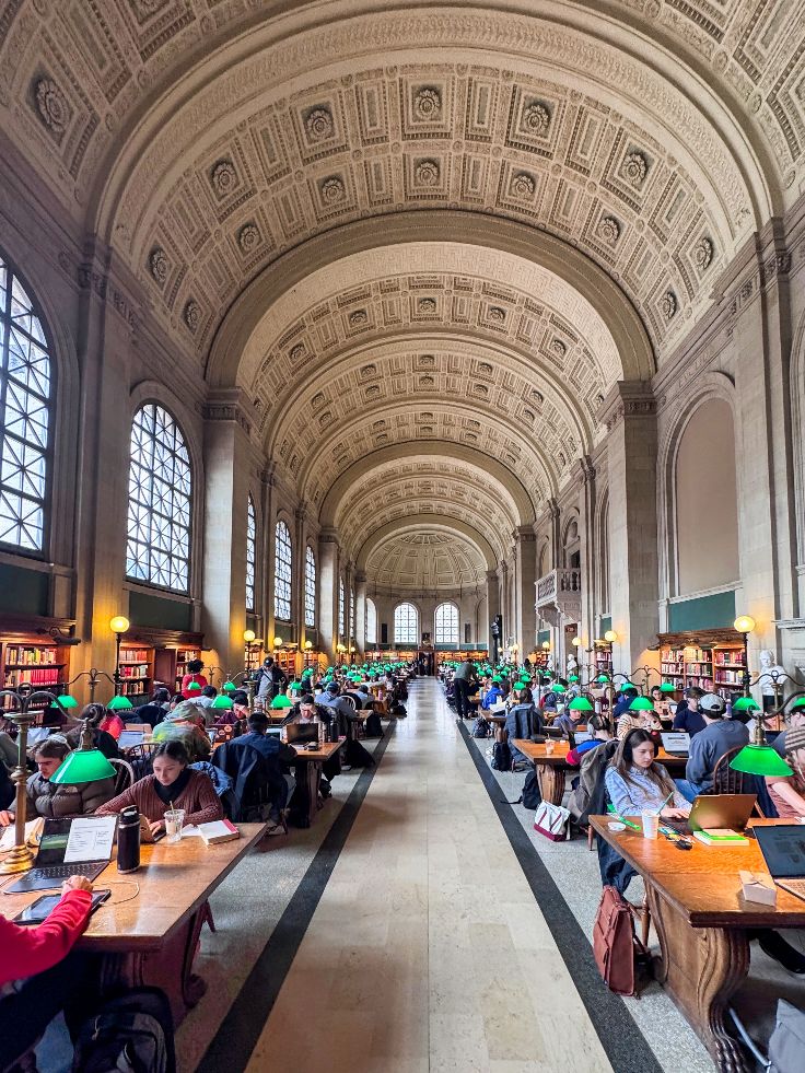  Bates Hall is the Library’s main reading room. The design is Beaux-Arts, with a barrel-vault, coffered ceiling, Roman thermal windows, domes at each end, and blind arches 