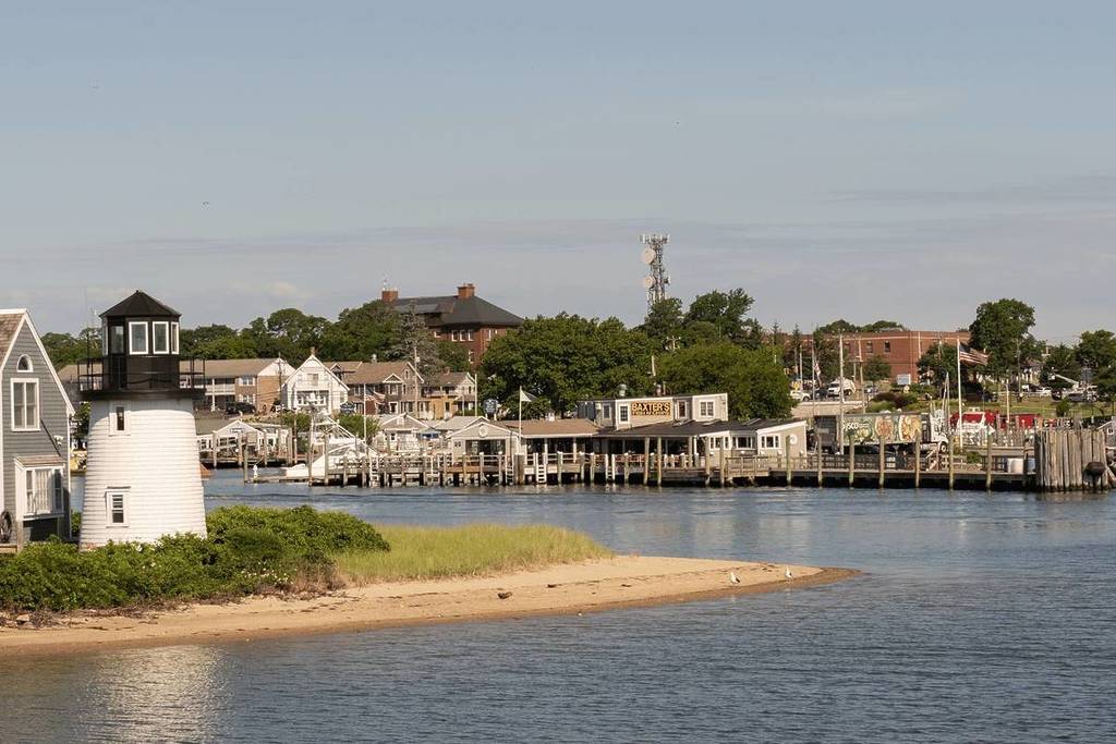 Hyannis Port, Massachusetts-July 6, 2022: View of the charming Hyannis Port light house and restaurants in the Hyannis Port harbor on a summer afternoon.