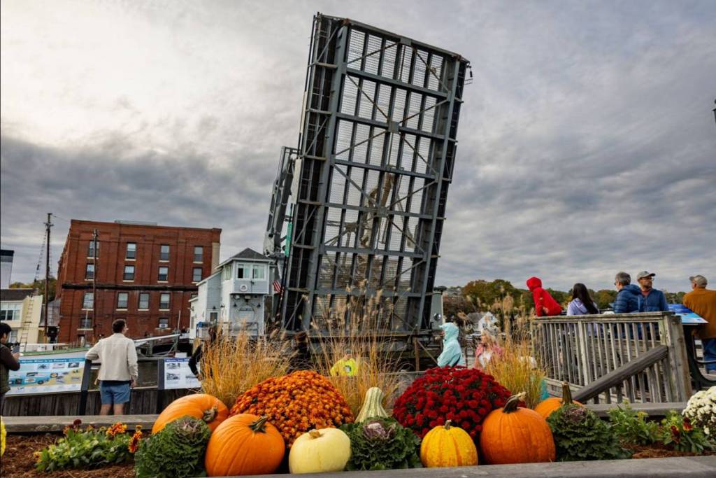Visitors and residents gather along the Mystic River in Mystic, Connecticut on a Fall afternoon on October 19, 2025 to take in the sights and sounds near the Bascule Bridge, a drawbridge that began operating in 1924