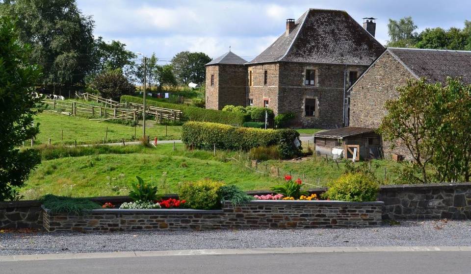 Two hours from Brussels, this secret village perched on a hill hides a 17th-century castle farm and a World War II memorial—and almost no one knows about it!