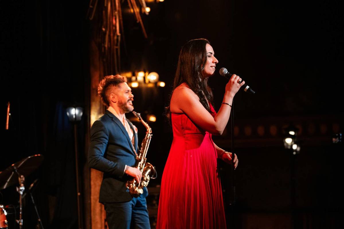 Plano medio de un saxofonista y una cantante de jazz sobre un escenario en The Jazz Room.