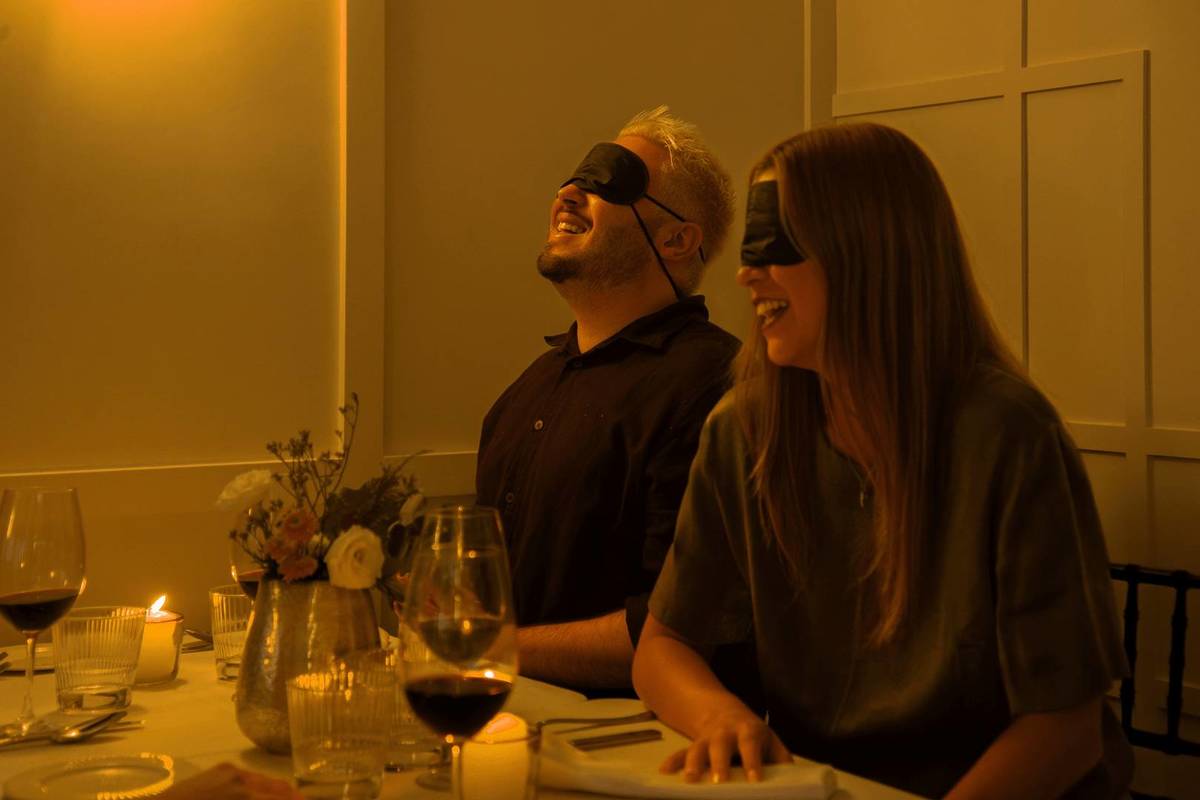 Dos peronas durante Dining in the Dark.