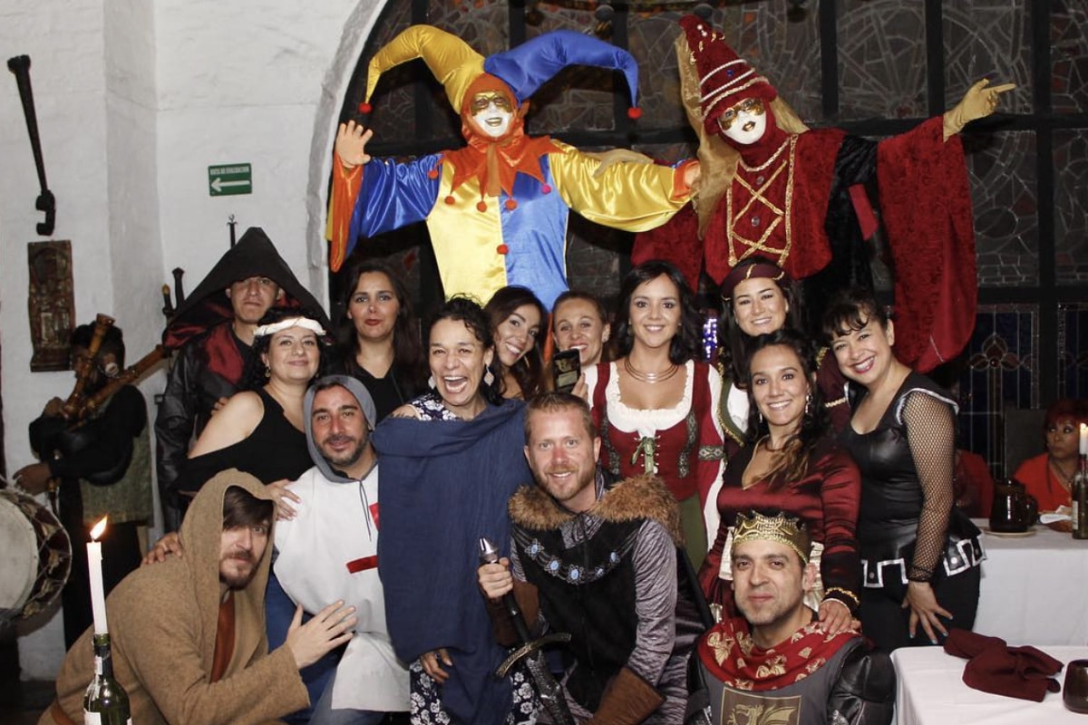 Grupo de personas disfrazadas de época medieval durante la cena show temática del restaurante Mesón del Cid