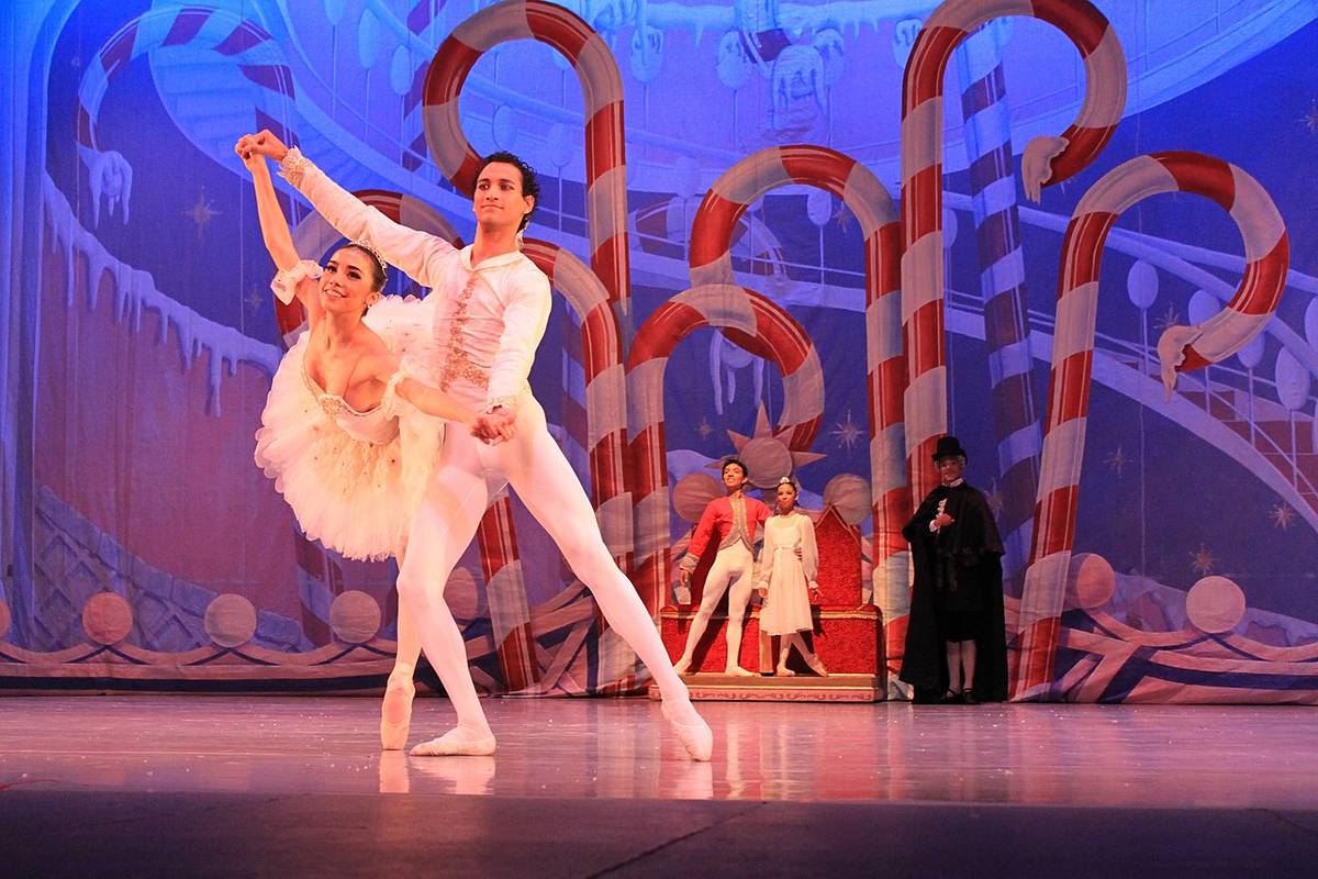 Bailarines interpretan el gran pas de deux en la escena final de El Cascanueces CDMX, rodeados de bastones de caramelo y decorado festivo