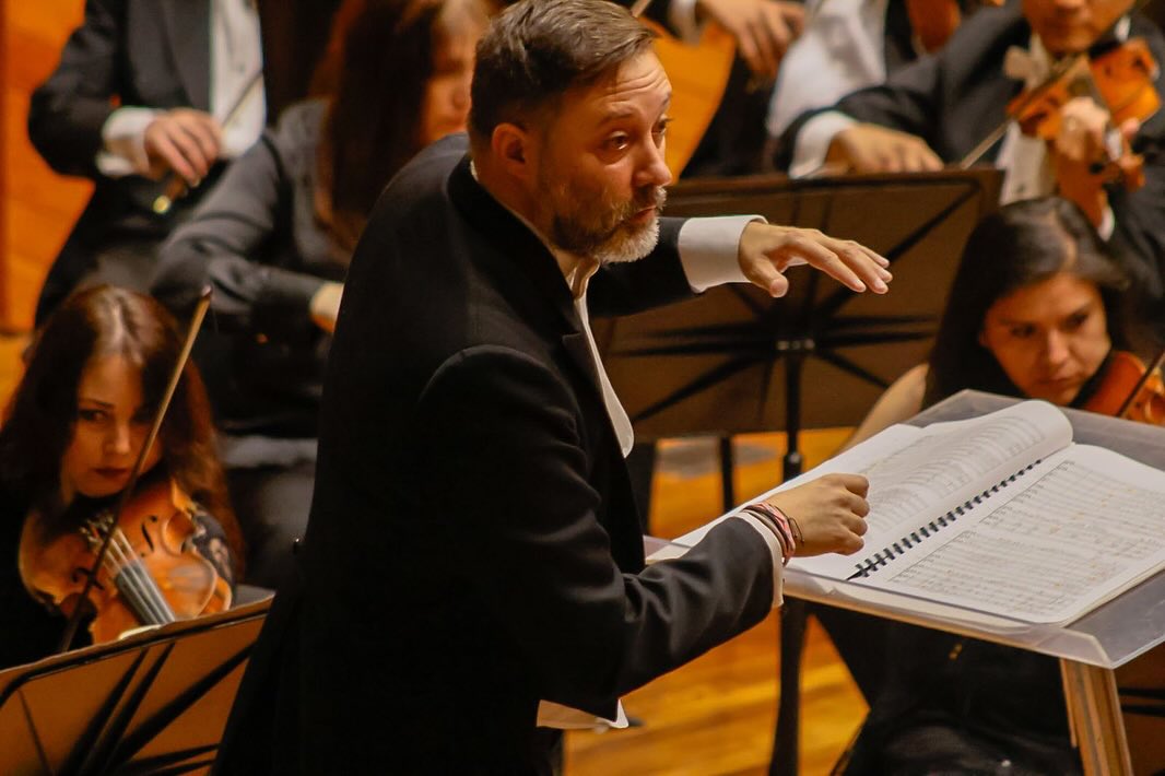 Primer plano de Rodrigo Macías dirigiendo la Orquesta Sinfónica del Estado de México.
