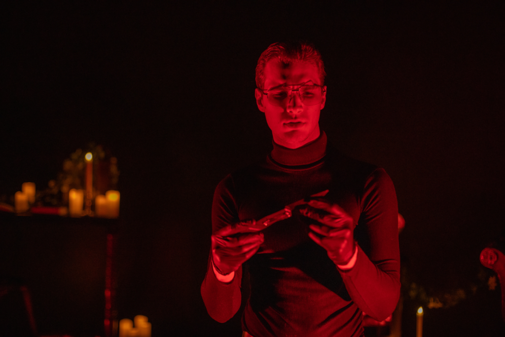 A medium shot of a Serial Killer Speakeasy actor looking at a knife.