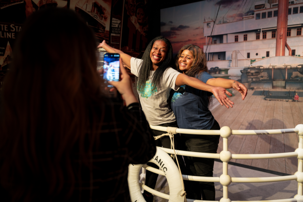 Some girls strike the famous pose at the bow of the ship during “Titanic: An Immersive Experience.”