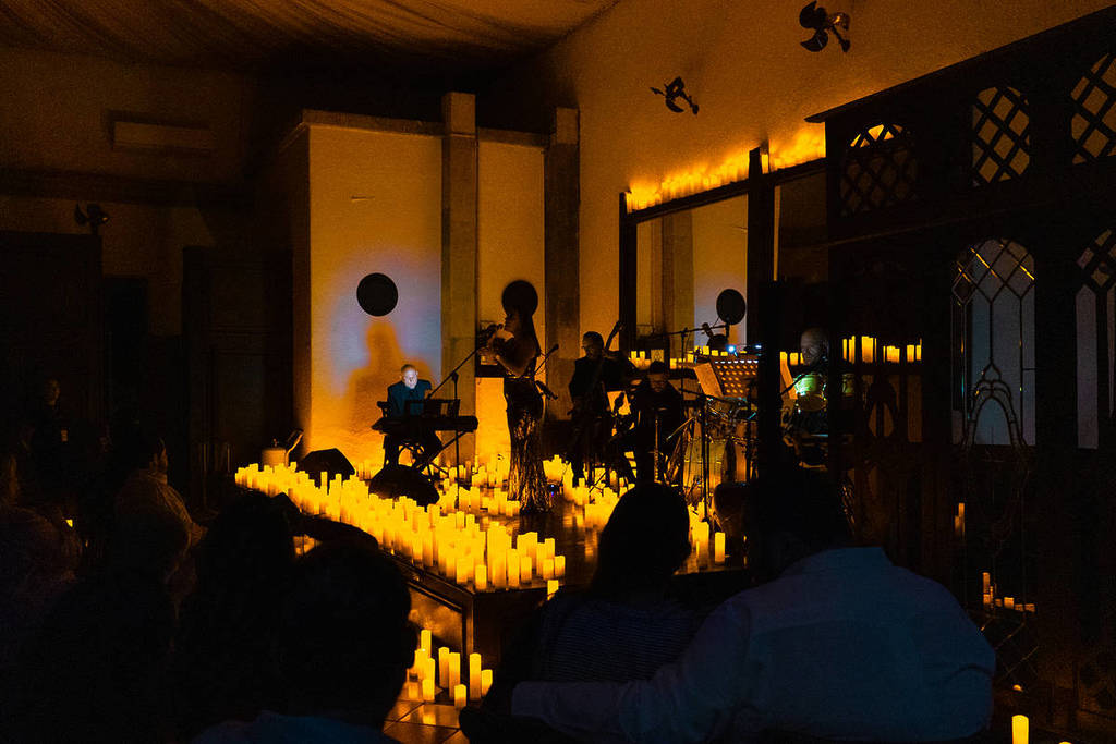 Un cuarteto de cuerda toca en la Mansión Magnolia sobre un escenario cubierto de velas durante un concierto Candlelight.