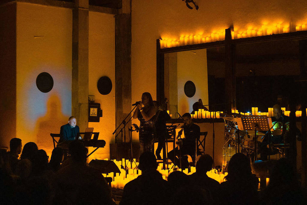 A string quartet performs at the Magnolia Mansion on a stage covered in candles during a Candlelight concert.