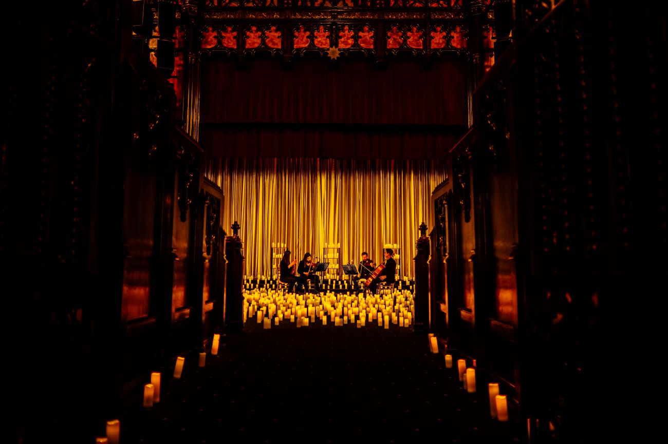 A string quartet performing at the Scottish Rite Theatre in Indianapolis surrounded by candlelight.