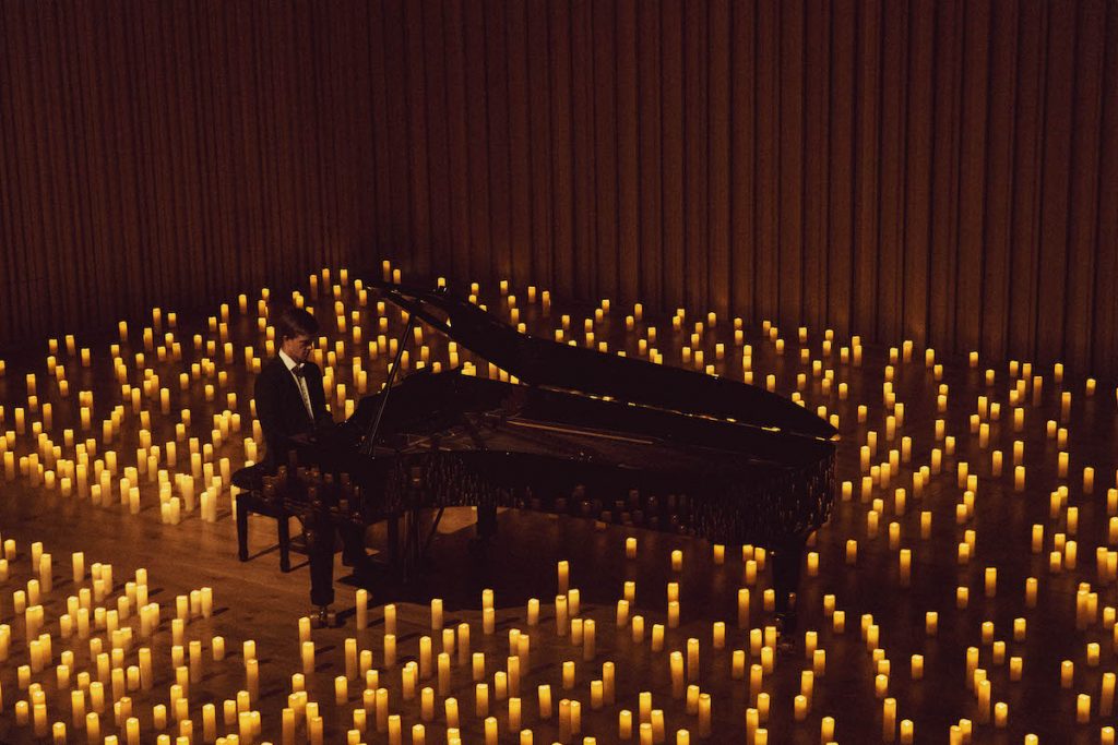 pianist performs among candlelight