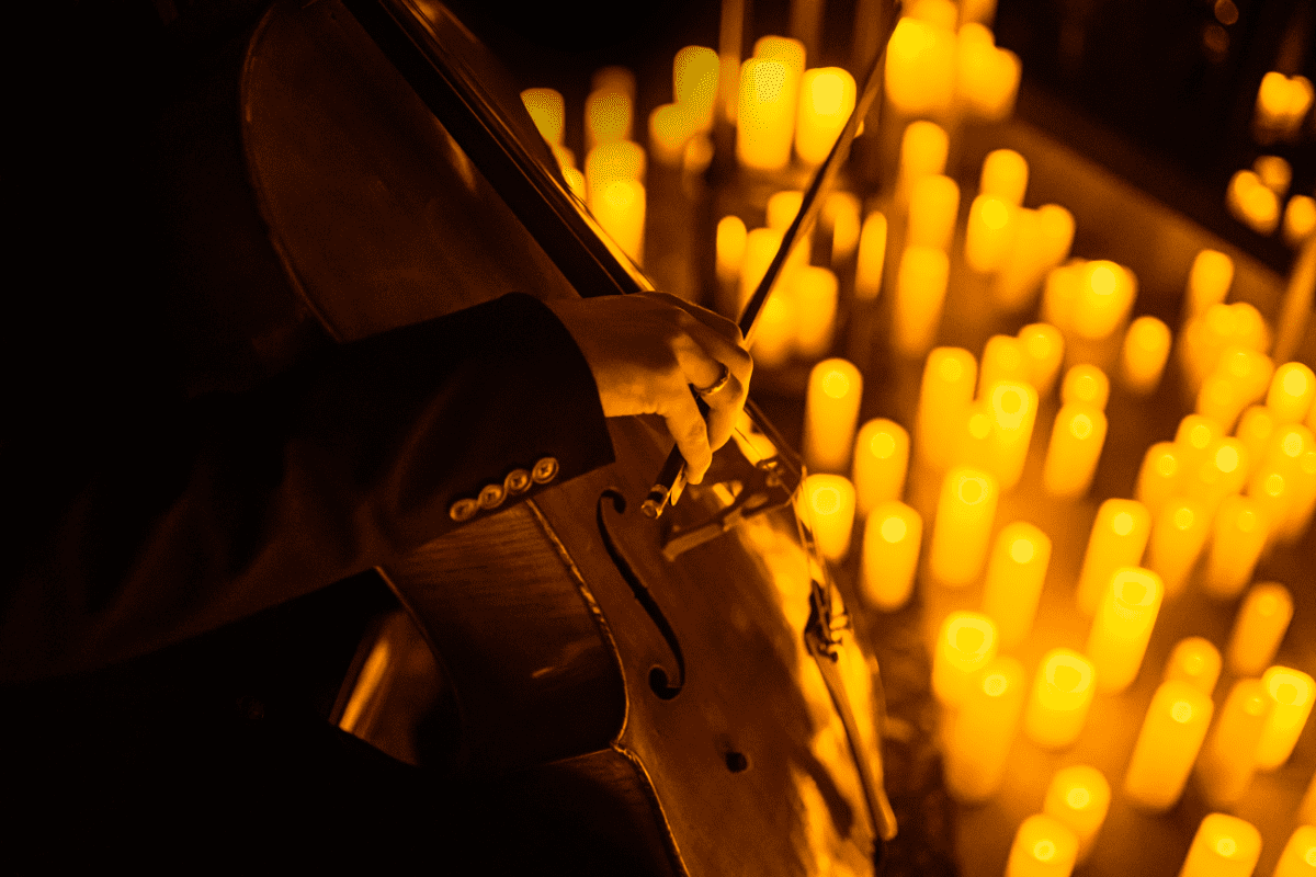 a cello player performing by candlelight