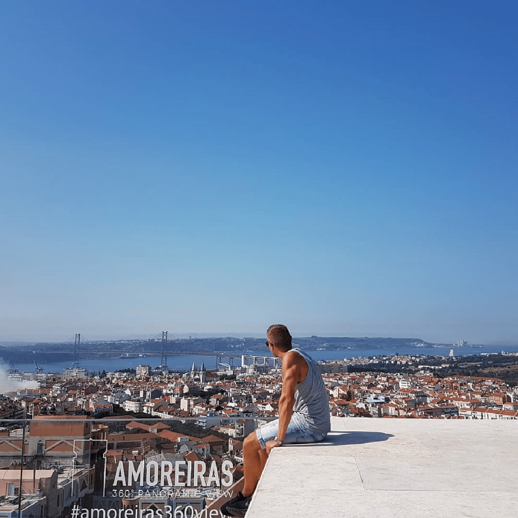 homem sentado no miradouro das amoreiras em lisboa