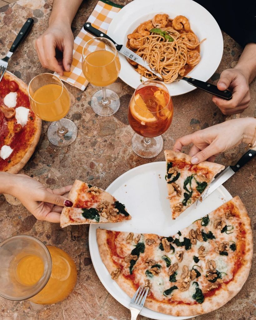 persone che mangiano la pizza alla pizzeria zerozero a Lisbona