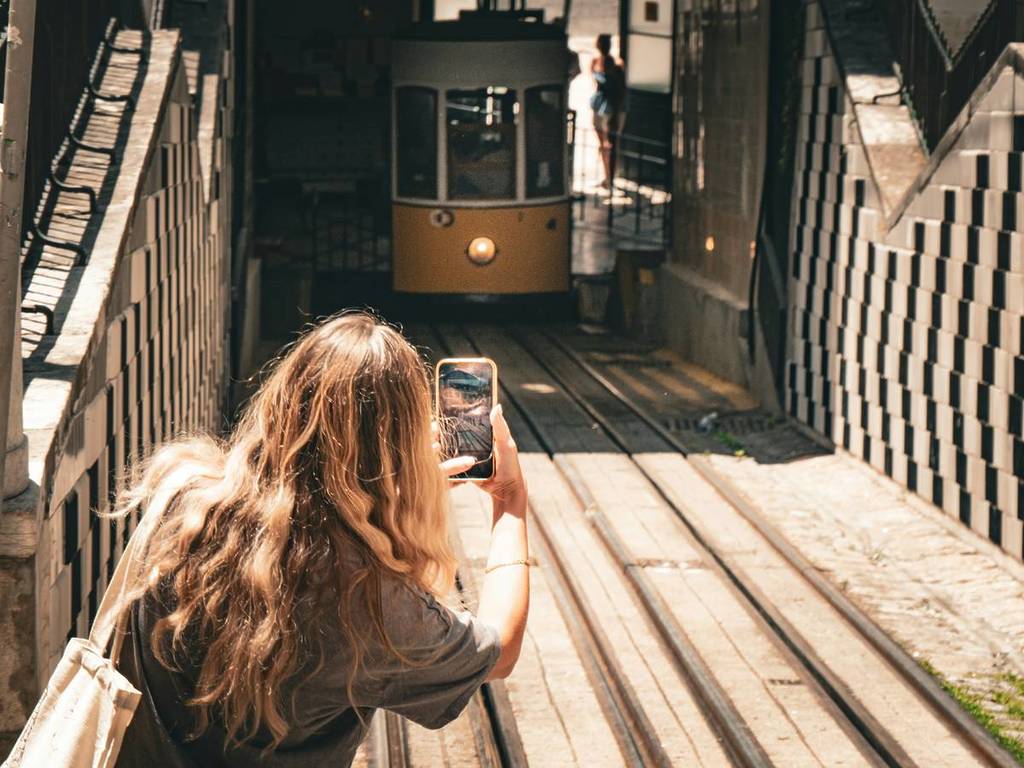 Mujer tomando una foto en el ascensor de Bica, fin de semana en Lisboa.