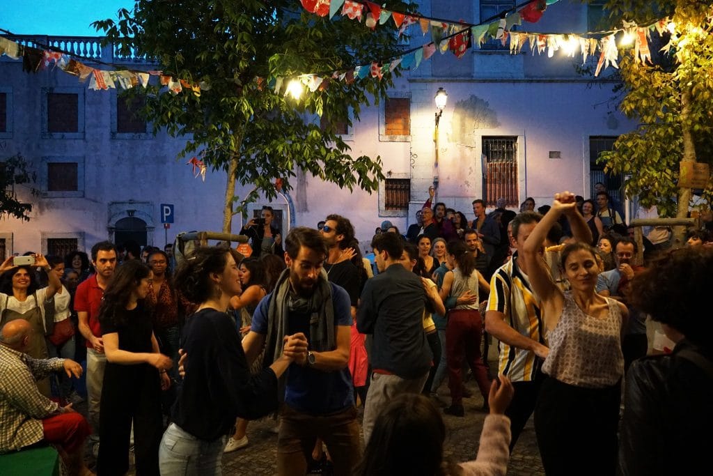 pessoas a dançar num arraial dos santos populares de lisboa no bairro da mouraria