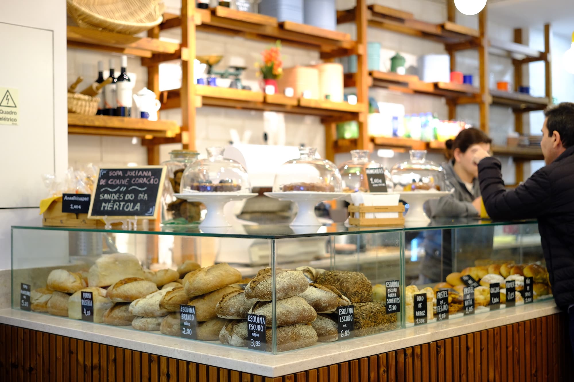 pessoas ao balcão da nova loja pão da esquina em alvalade