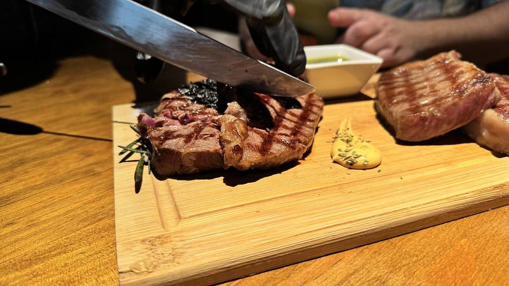 pessoa a cortar carne wagyu no restaurante atalho