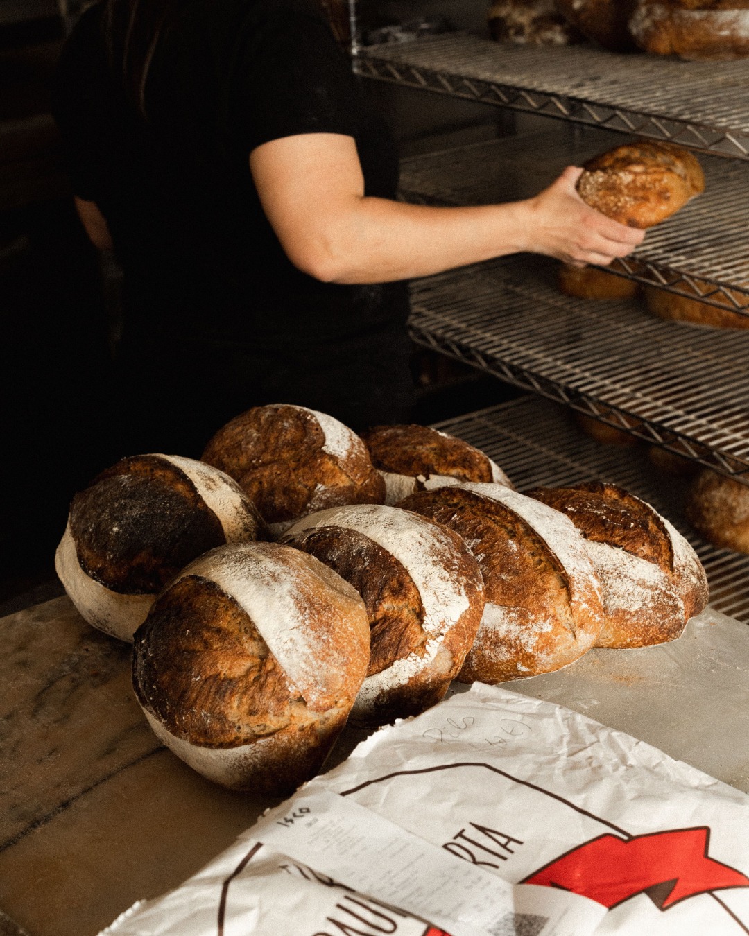 padeiro a arrumar pão na prateleira
