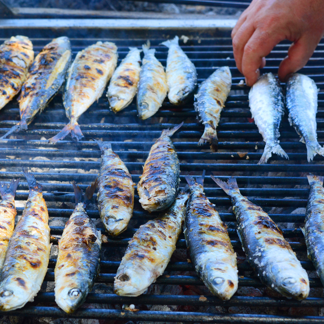 assador a grelhar peixe no restaurante solar do kadete