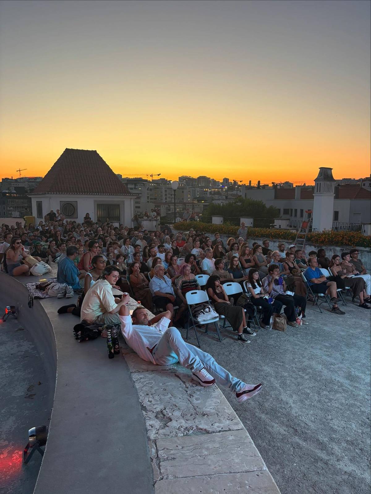 pessoas a assistir a um filme nas sessões de cinema ao ar livre no jardim do torel