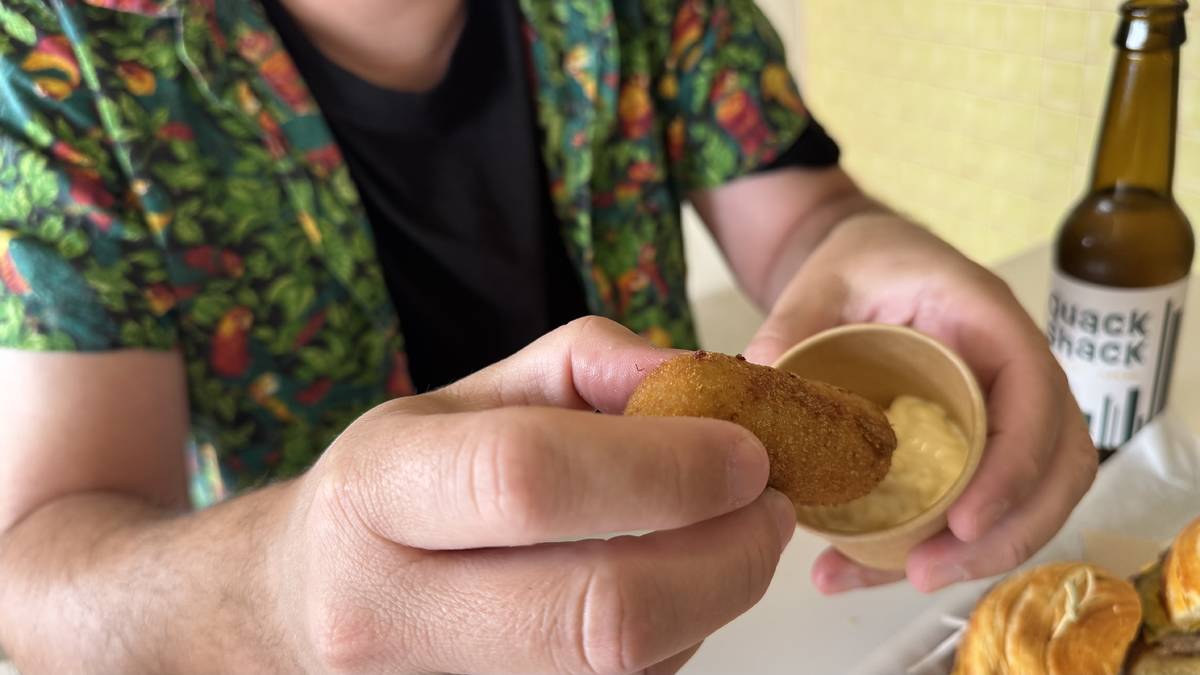 ringo a mergulhar o croquete quackette no molho da casa