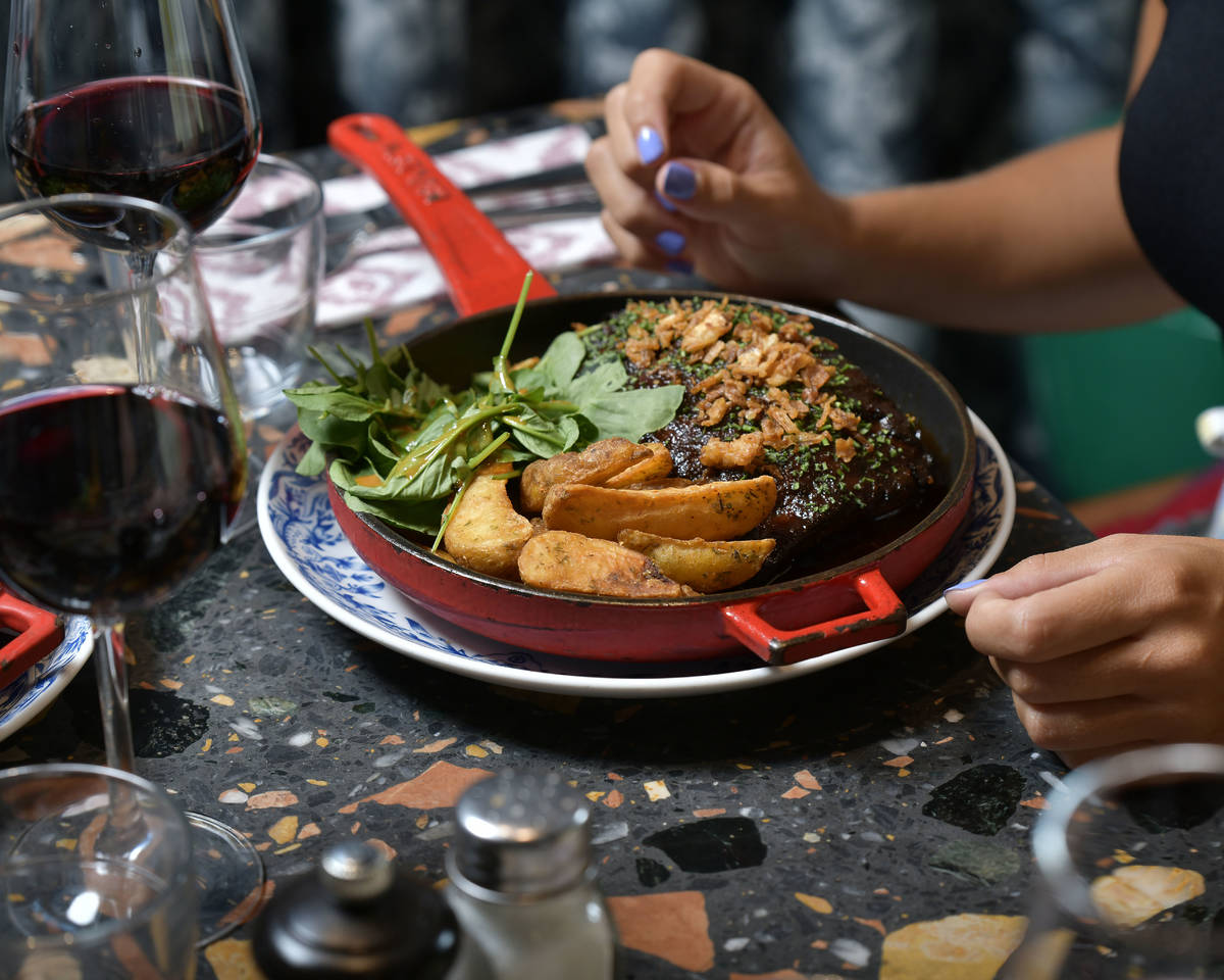 pessoa a comer bochechas de porco, menu de almoço no mama shelter